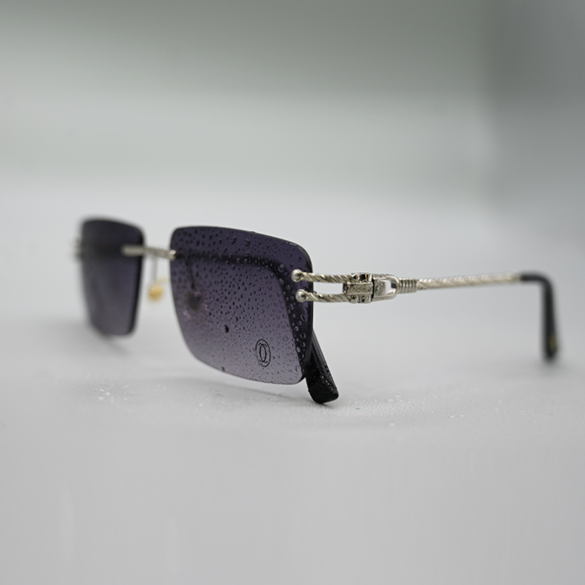 نظارة كارتير 3001 شمسية بعدسات مستطيلة رمادية متدرجة وإطار معدني فضي مع أذرع سوداء مزخرفة وشعار الماركة المحفور.