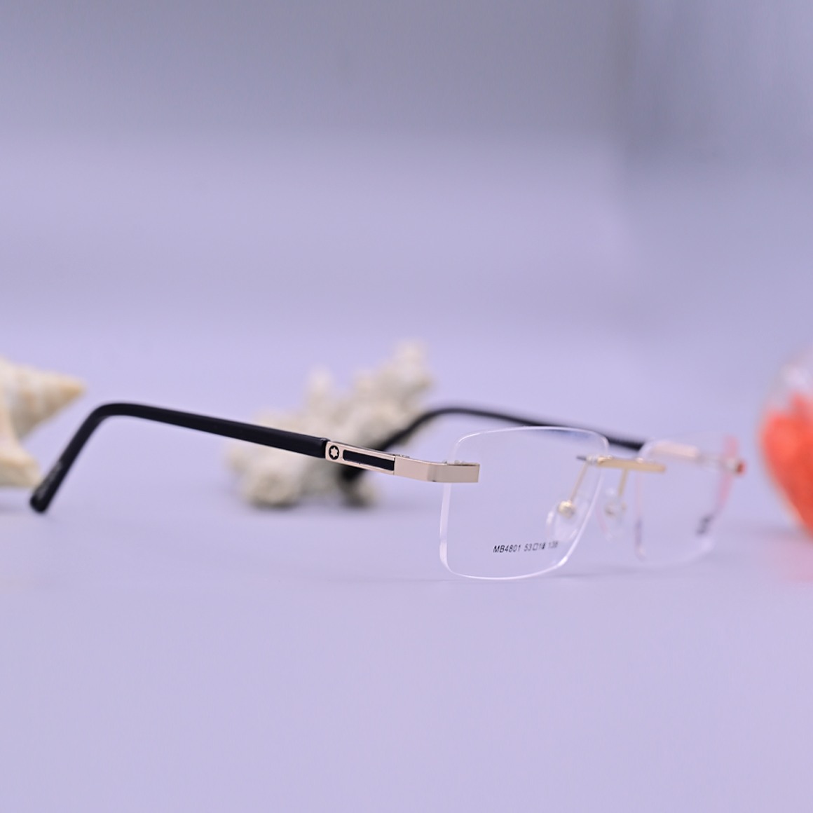 نظارة طبية مونت بلانك موديل 4801 دائرية بدون إطار مع جسر أنف ذهبي وأذرع سوداء وتفاصيل فاخرة عند المفصلات.