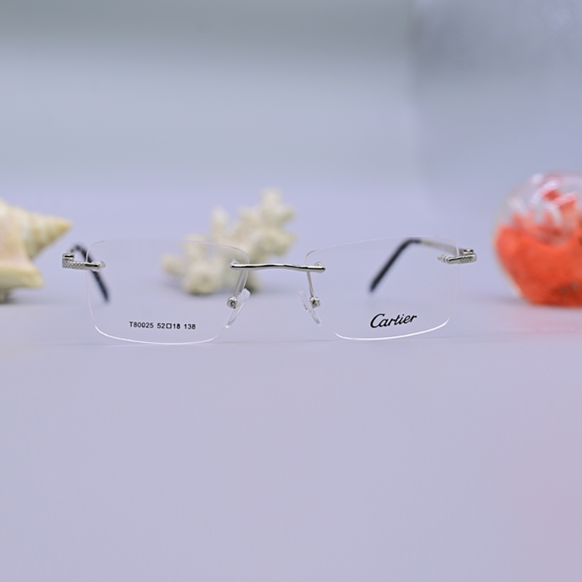 نظارة طبية فاخرة من ماركة كارتير (Cartier) موديل 80025، تصميم بدون إطار (Rimless) بجسر وأذرع معدنية باللون الفضي اللامع وأطراف سوداء، متوفرة لدى عين العون.