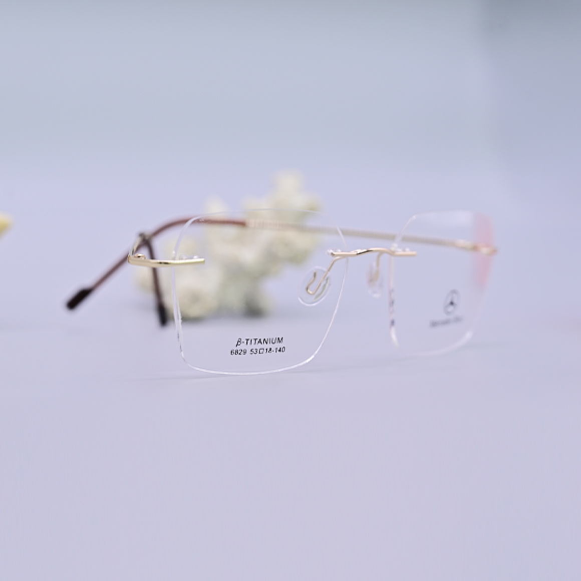نظارة طبية فاخرة من ماركة مرسيدس بنز موديل 6829، تصميم بدون إطار (Rimless) مع جسر وأذرع معدنية باللون الذهبي ونهايات بنية، متوفرة لدى عين العون.