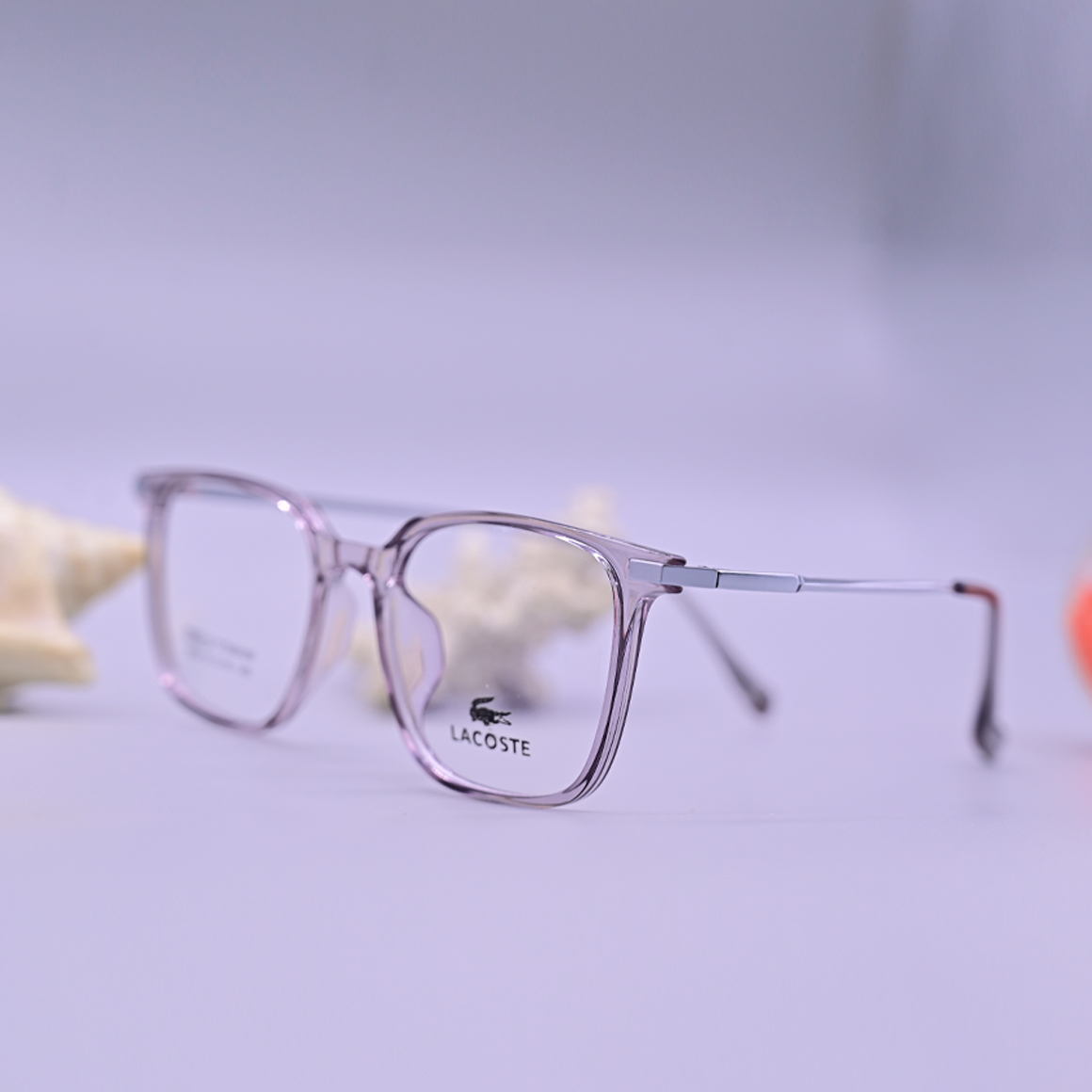 نظارة طبية ماركة لاجوست موديل 6004 بإطار دائري شفاف مائل للرمادي واللافندر وتصميم كلاسيكي مريح للنظر