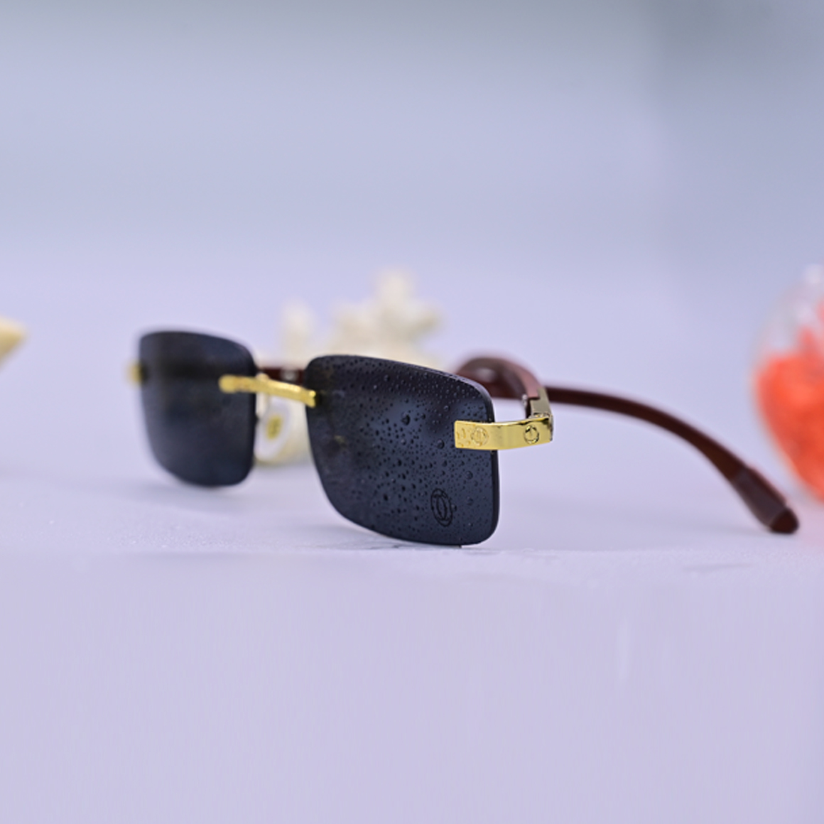 نظارة طبية فاخرة ماركة كارتير موديل 3021، تصميم بدون إطار (Rimless) بعدسات رمادية داكنة وأذرع خشبية بنية مع تفاصيل معدنية ذهبية، متوفرة لدى عين العون.