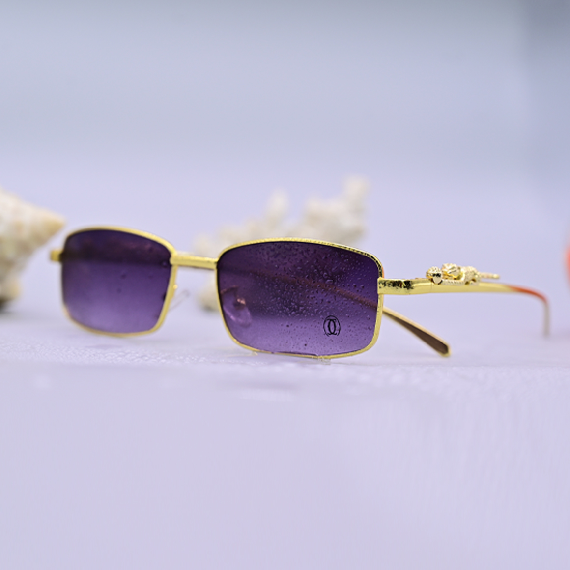 نظارة شمسية فاخرة ماركة كارتير موديل 3018، تصميم بدون إطار (Rimless) بعدسات بنية متدرجة وأذرع معدنية ذهبية بنقشة خشبية داكنة، متوفرة لدى عين العون.