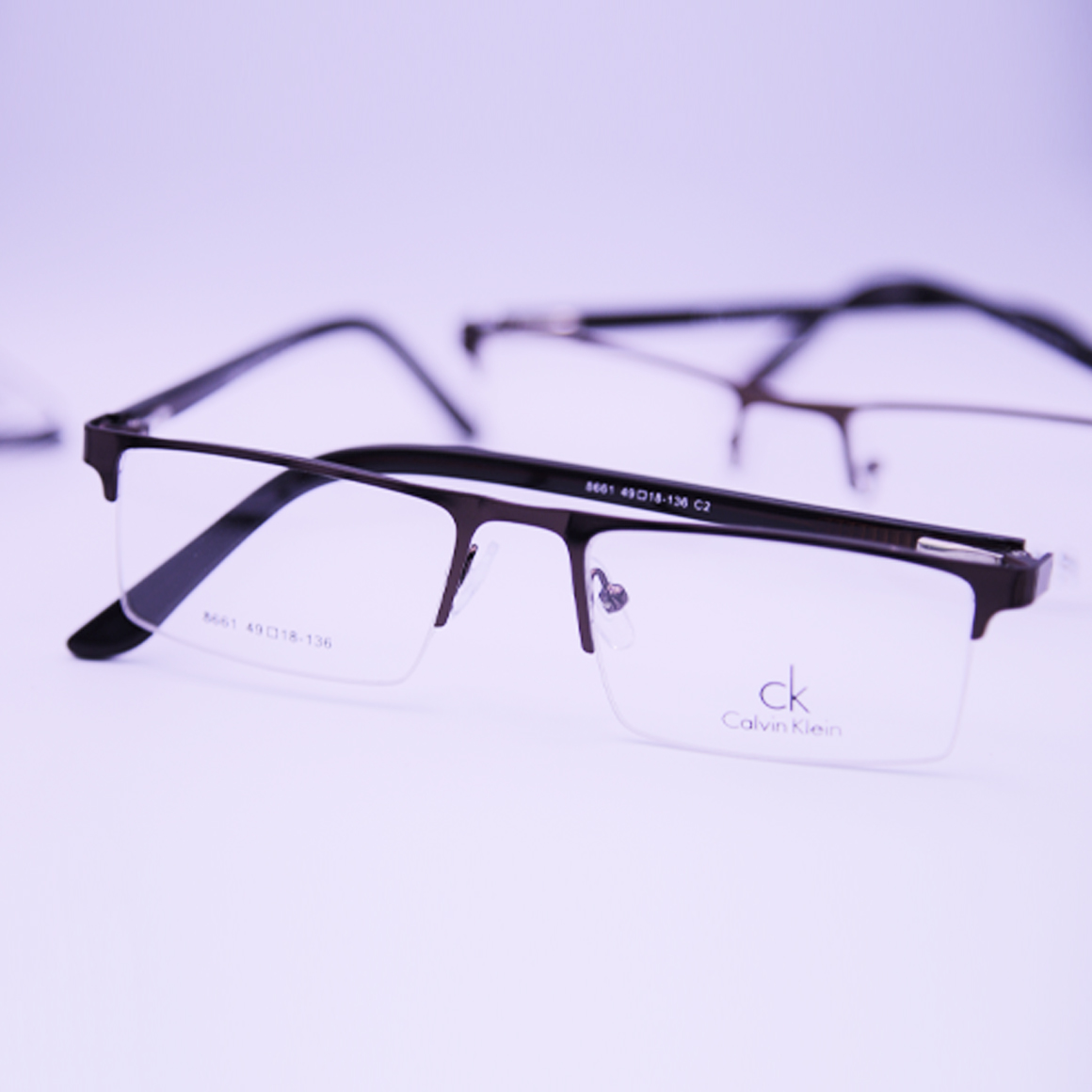 نظارة كالفين كلين (Calvin Klein) طبية رجالية موديل 8661 بنمط نصف حافة وشكل مستطيل بلون داكن فخم مع أذرع نحيفة مريحة من تشكيلة متجر عين العون.