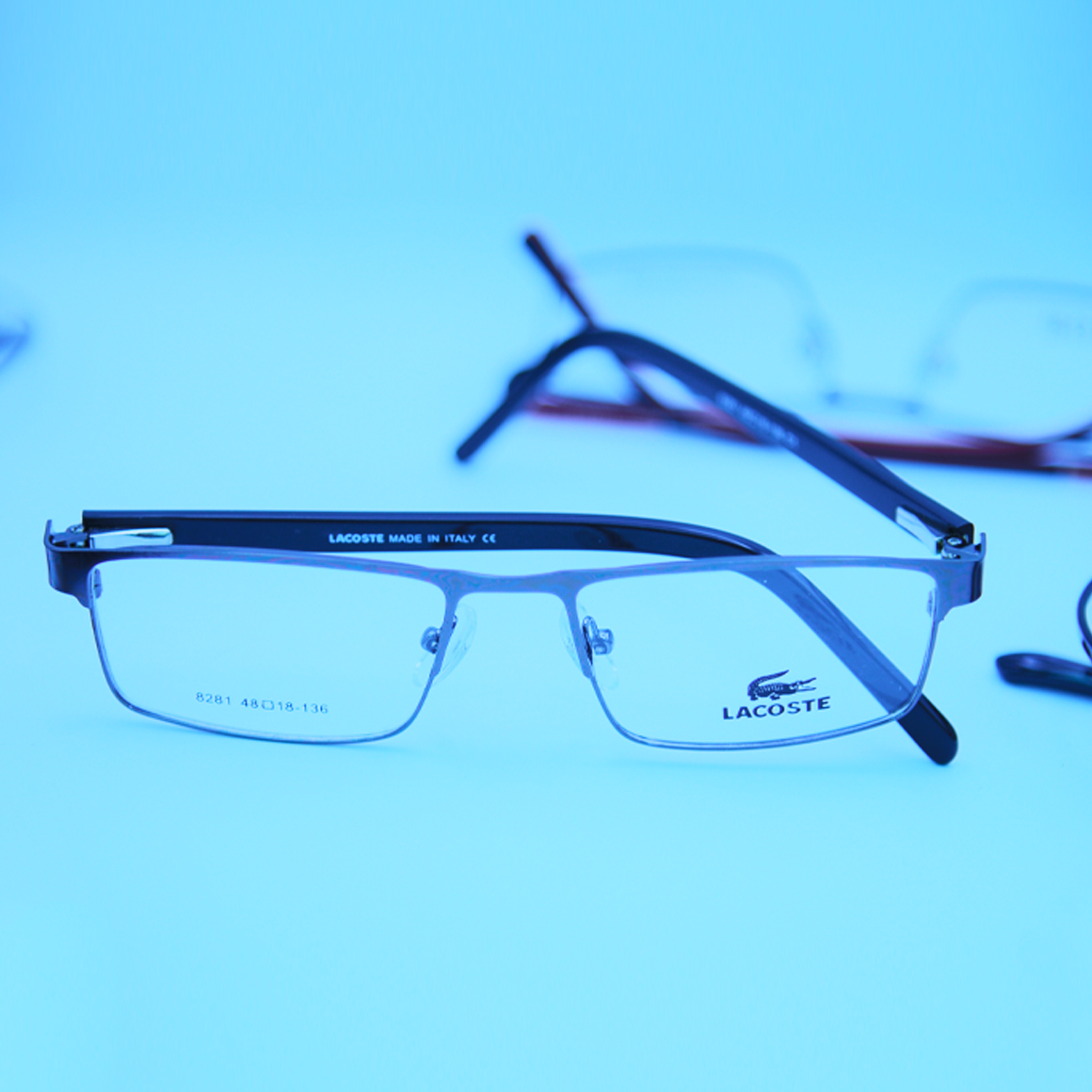 نظارة لاجوست (Lacoste) طبية موديل 8281 بنمط نصف حافة وتصميم مستطيل بلون داكن فخم مع أذرع انسيابية تحمل شعار الماركة من متجر عين العون.