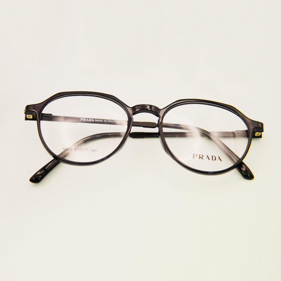 نظارة برادا (Prada) طبية موديل 9003 بإطار كامل وتفاصيل هندسية دقيقة، تمزج بين الانسيابية والزوايا المدروسة لتعكس رقي الذوق الإيطالي، من متجر عين العون.